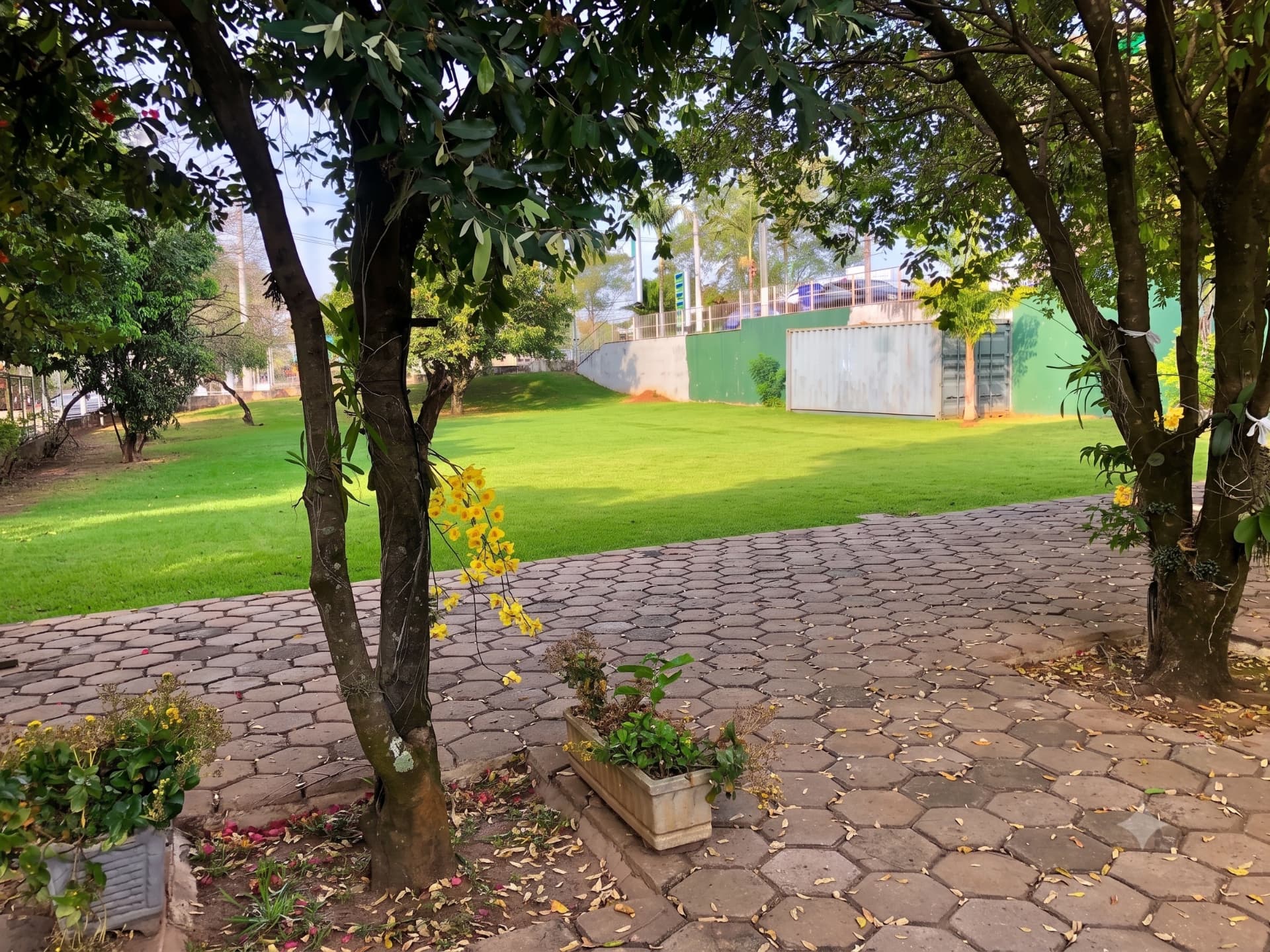 Área externa com gramado e jardim ao lado do restaurante